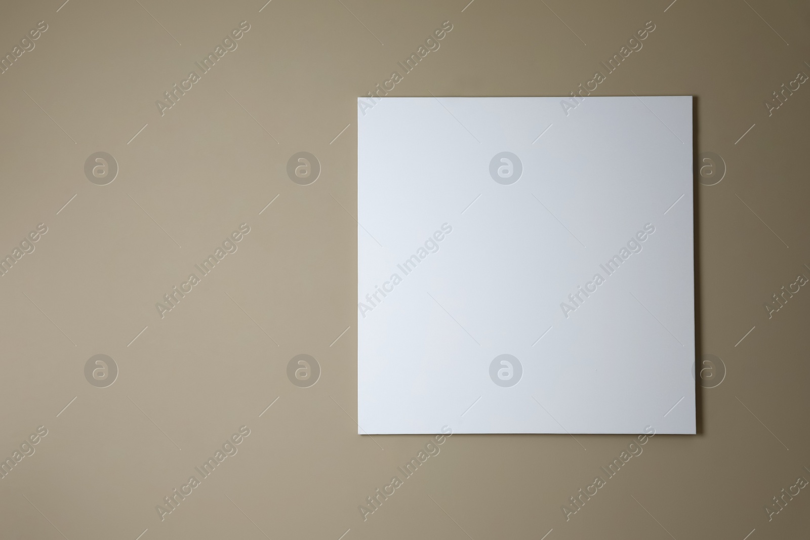 Photo of Blank canvas on beige wall. Space for design