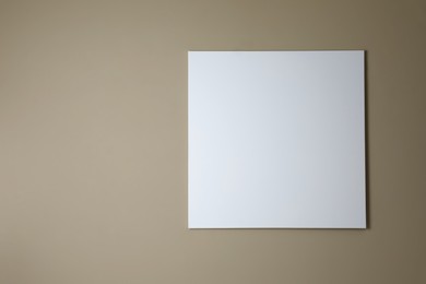 Blank canvas on beige wall. Space for design