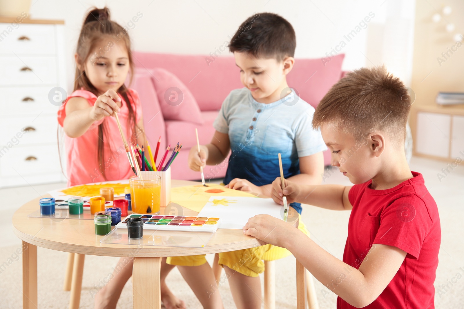 Photo of Cute little children painting at table in playing room