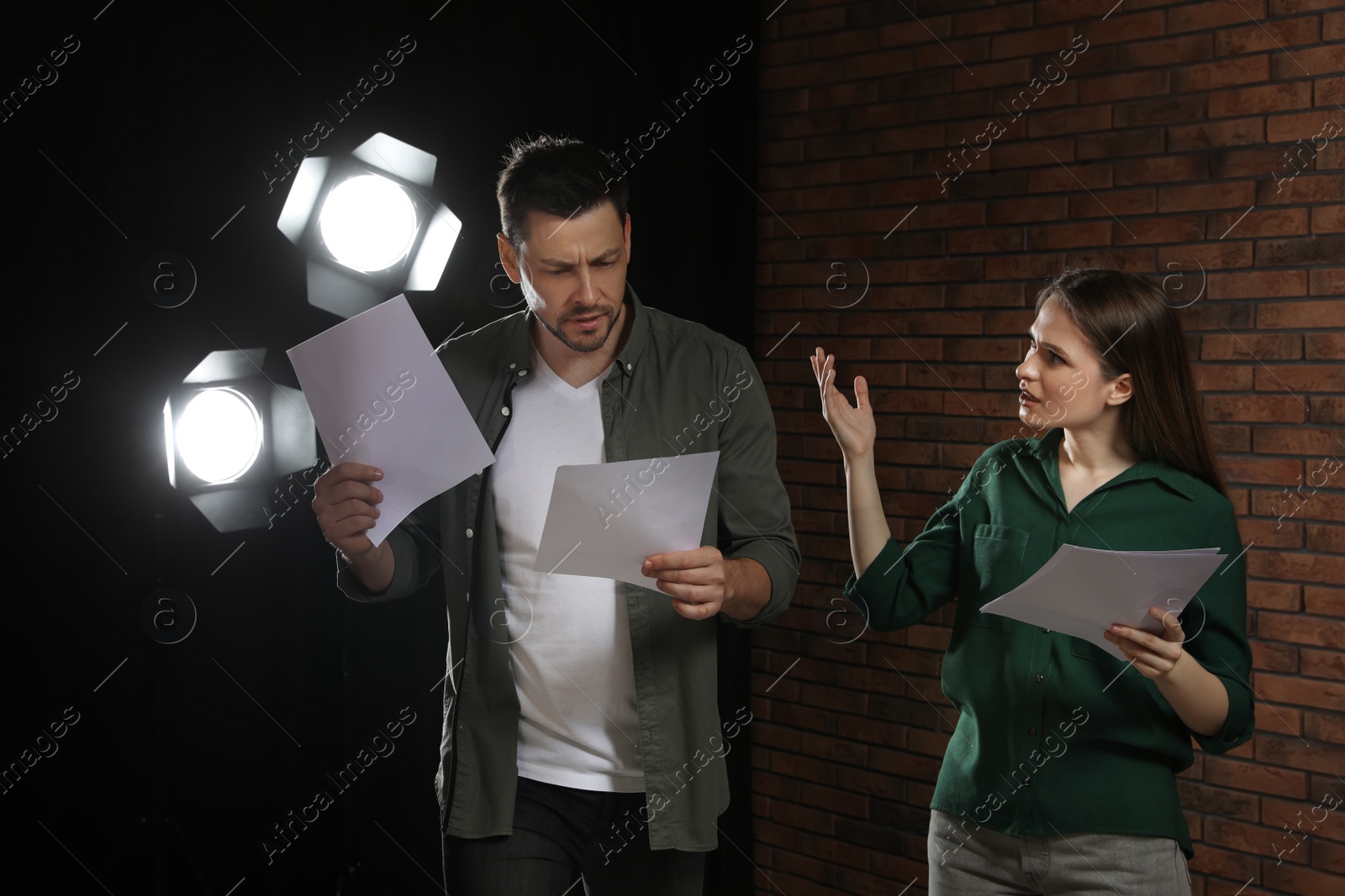 Photo of Professional actors reading their scripts during rehearsal in theatre