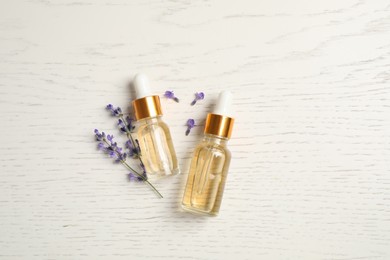 Flat lay composition with lavender essential oil on white wooden background