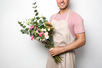 Florist with beautiful bouquet on light background, closeup