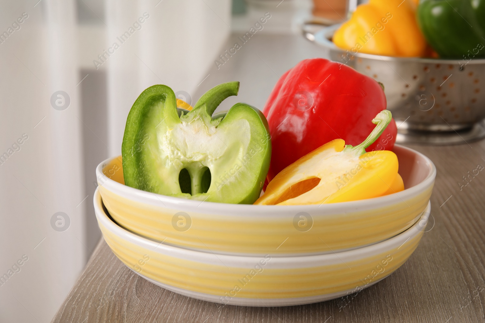 Photo of Plates with ripe paprika peppers on table