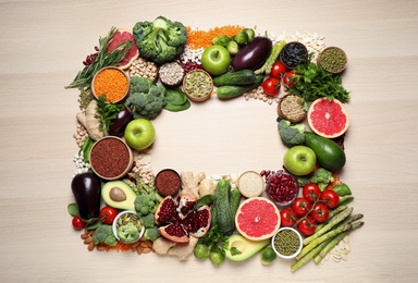 Frame of fresh vegetables, fruits and seeds on light table, flat lay