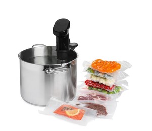 Photo of Thermal immersion circulator in pot and vacuum packs with different food products on white background. Sous vide cooking