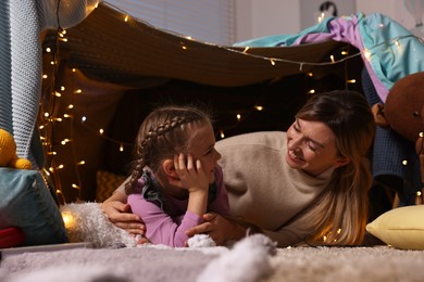 Photo of Mother and her daughter with laptop in play tent at home
