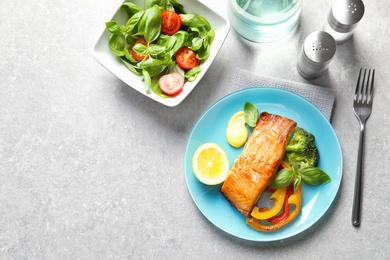 Photo of Tasty cooked salmon with vegetables served for dinner, top view