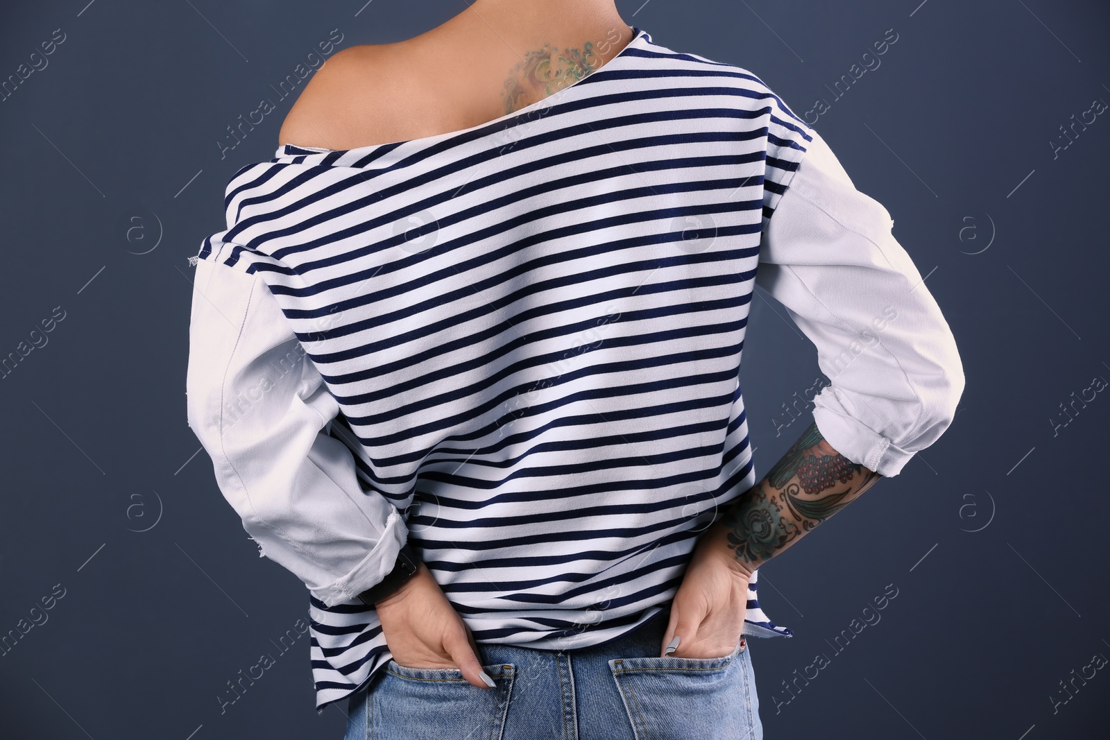 Photo of Trendy young woman with tattoo on color background, closeup