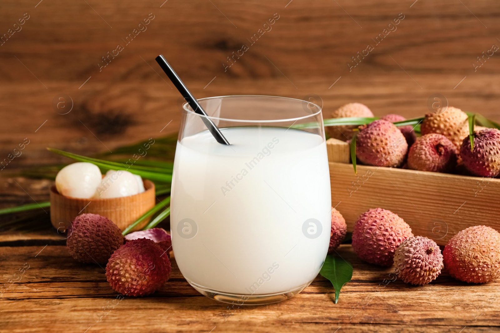 Photo of Lychee juice and fresh fruits on wooden table