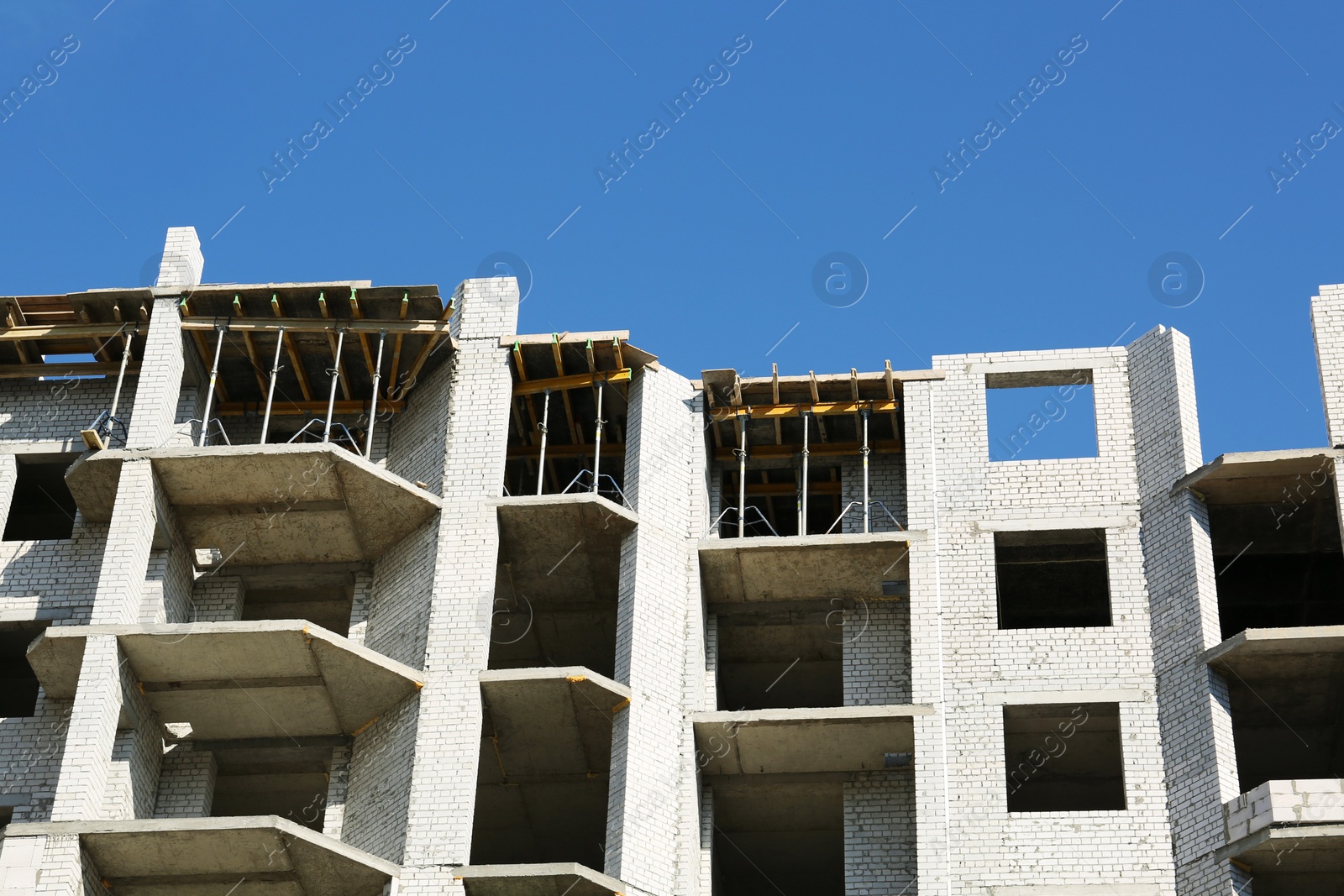 Photo of Construction site with unfinished building on sunny day, low angle view