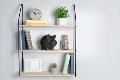 Photo of Cute piggy bank on shelf indoors. Stylish interior