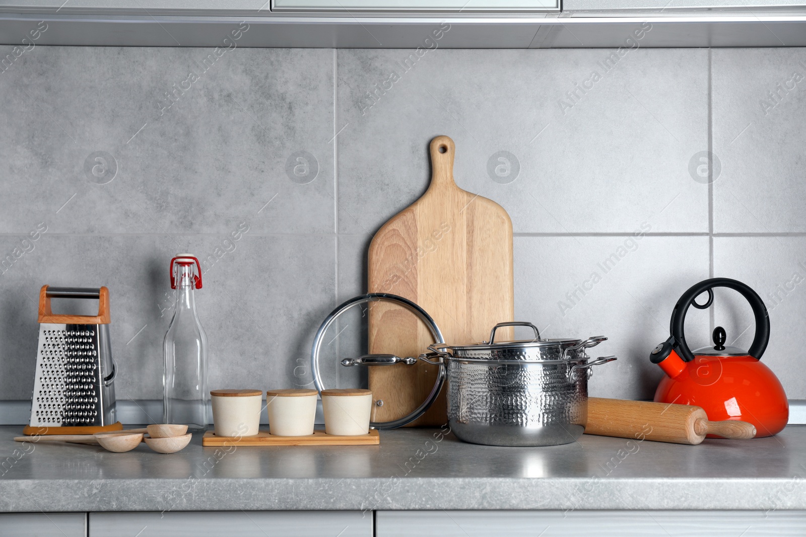 Photo of Set of different cooking utensils on grey countertop in kitchen