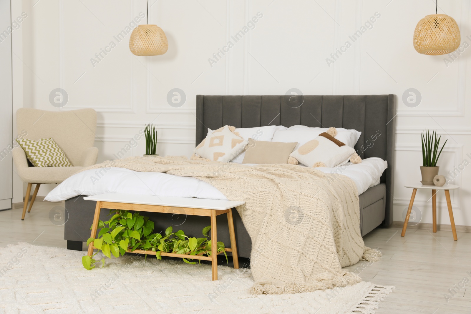 Photo of Stylish bedroom interior with large comfortable bed and armchair