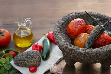 Ingredients for tasty salsa sauce, pestle and mortar on wooden table
