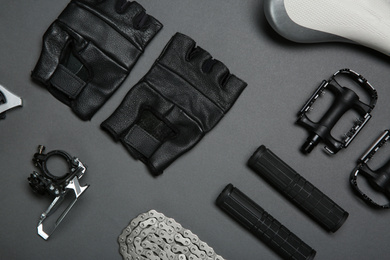 Set of different bicycle parts and gloves on grey background, flat lay