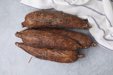 Photo of Fresh cassava roots on grey table, top view