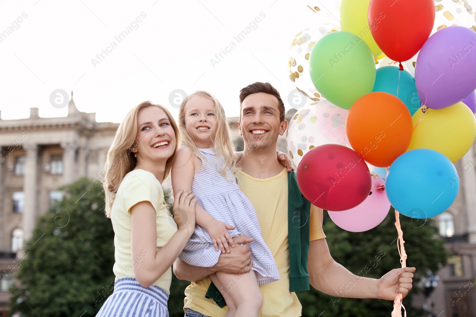 Photo of Happy family with colorful balloons outdoors on sunny day