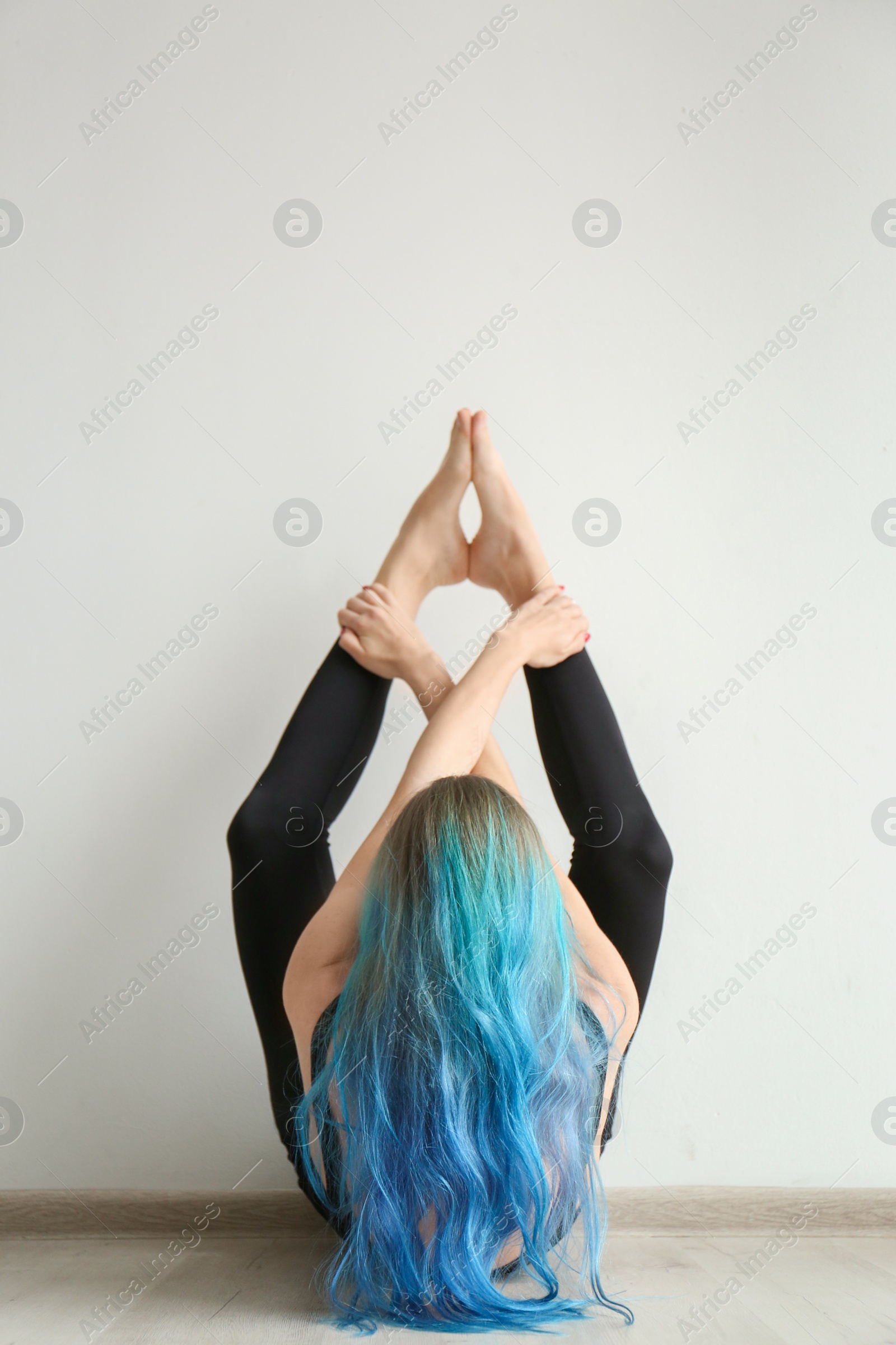 Photo of Young woman practicing yoga indoors