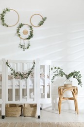 Stylish baby room decorated with eucalyptus branches