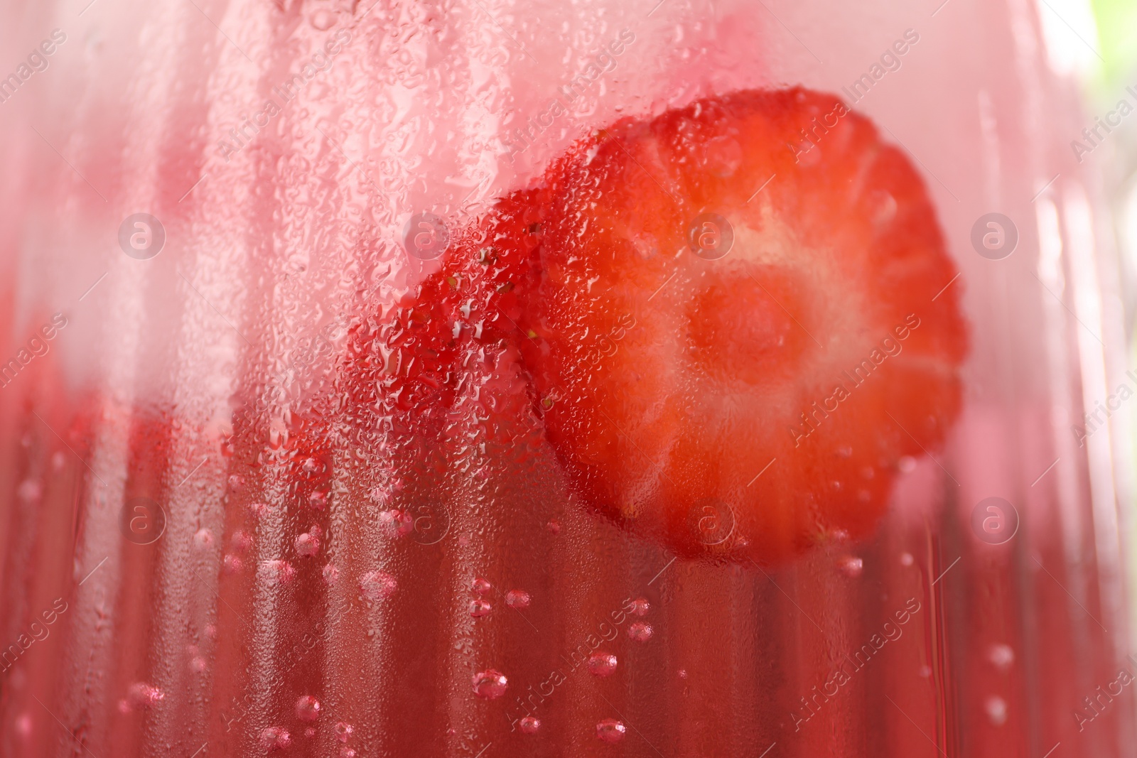 Photo of Freshly made strawberry lemonade in jug as background, closeup