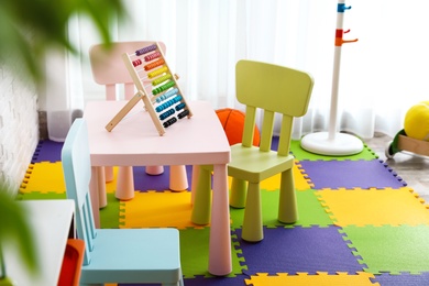 Photo of Stylish playroom interior with toys and modern furniture