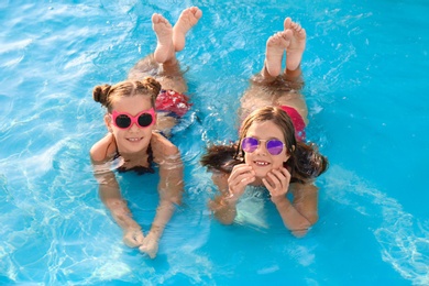 Photo of Happy cute girls in swimming pool on sunny day