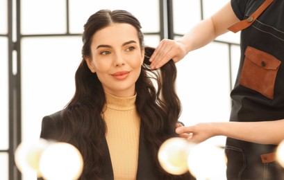 Hair styling. Professional hairdresser working with client indoors, closeup