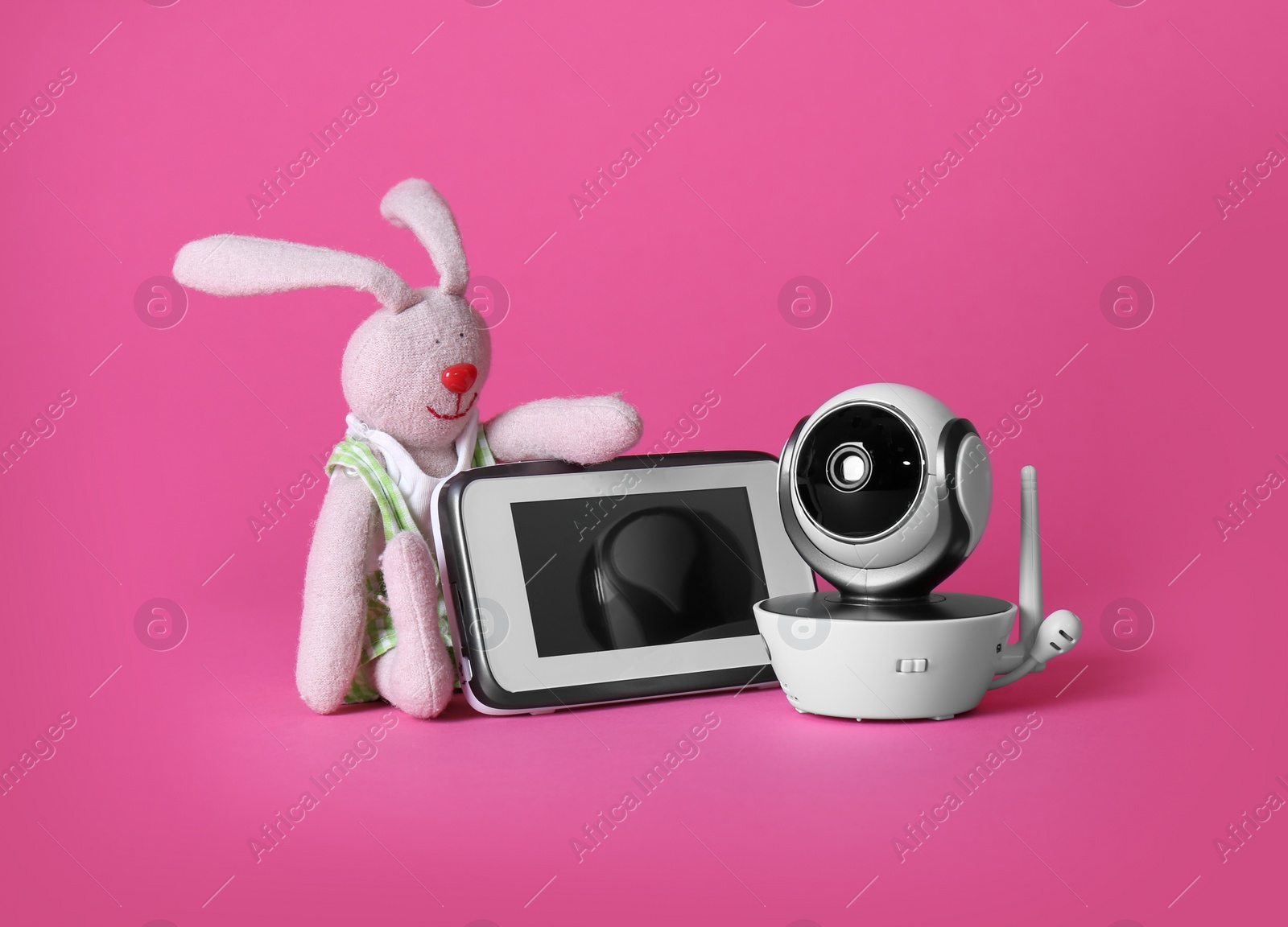 Photo of Modern CCTV security camera, toy bunny and monitor on color background. Space for text