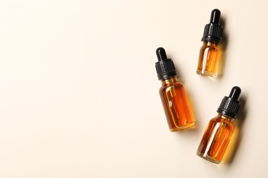 Photo of Cosmetic bottles of essential oils and space for text on color background, flat lay