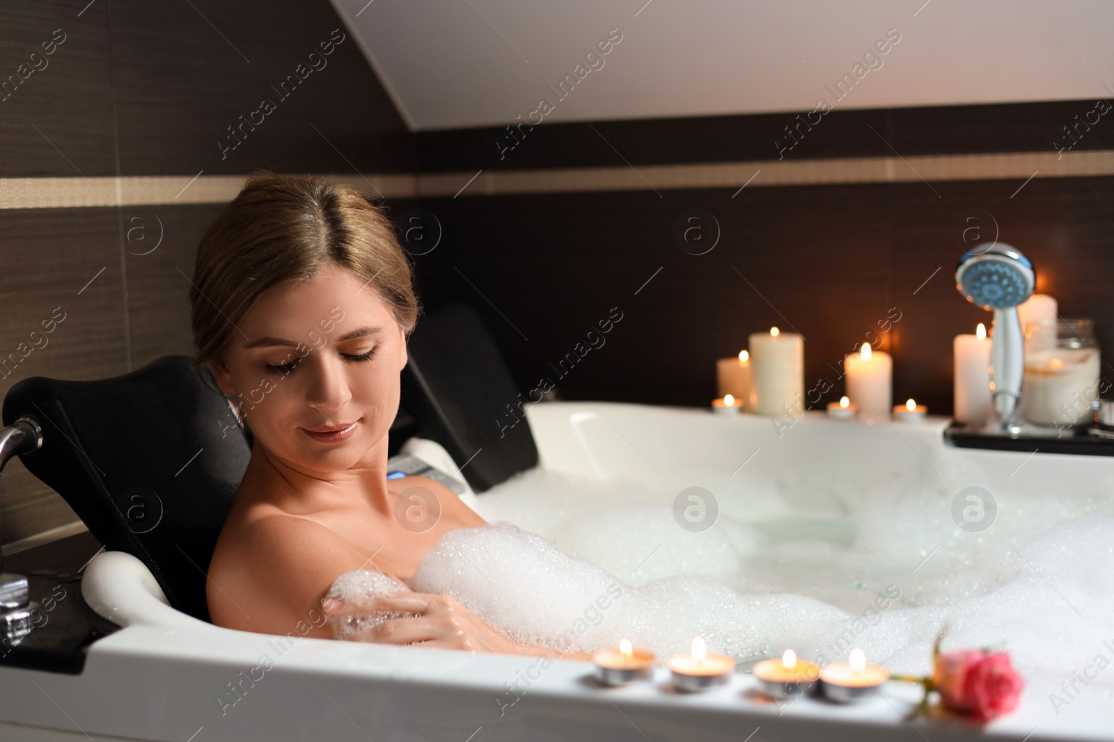 Photo of Beautiful woman taking bubble bath indoors. Romantic atmosphere