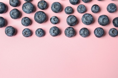 Tasty ripe blueberries on pink background, flat lay with space for text