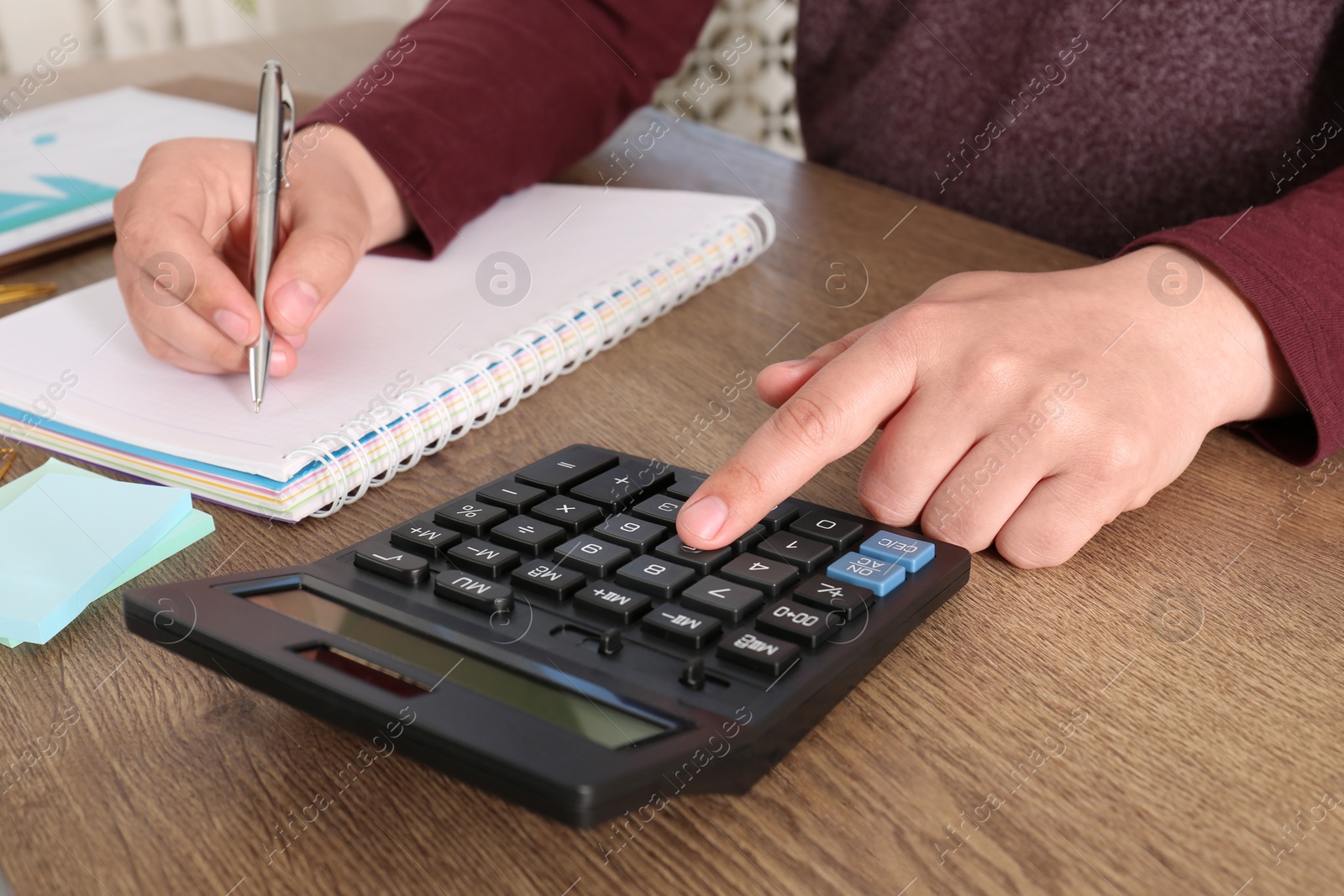 Photo of Man calculating pension at wooden table, closeup