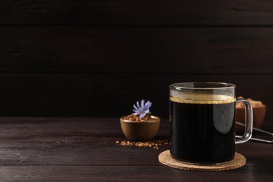 Glass cup of delicious chicory drink on wooden table, space for text