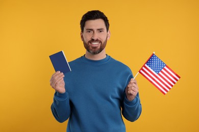 Photo of Immigration. Happy man with passport and American flag on orange background