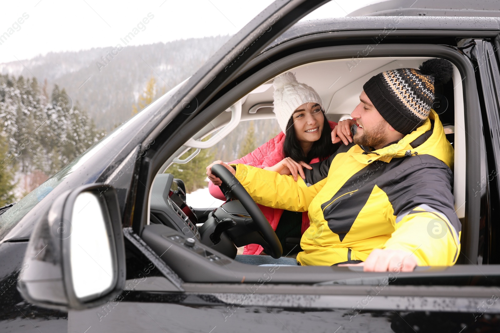 Photo of Happy couple in car outdoors. Winter vacation