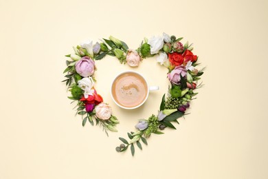 Photo of Beautiful heart made of different flowers and coffee  on beige background, flat lay