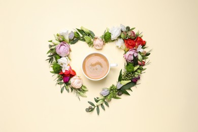 Beautiful heart made of different flowers and coffee  on beige background, flat lay