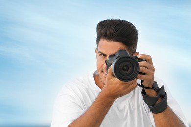 Photo of Photographer taking picture with professional camera outdoors