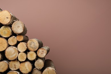Cut firewood on pink background. Space for text