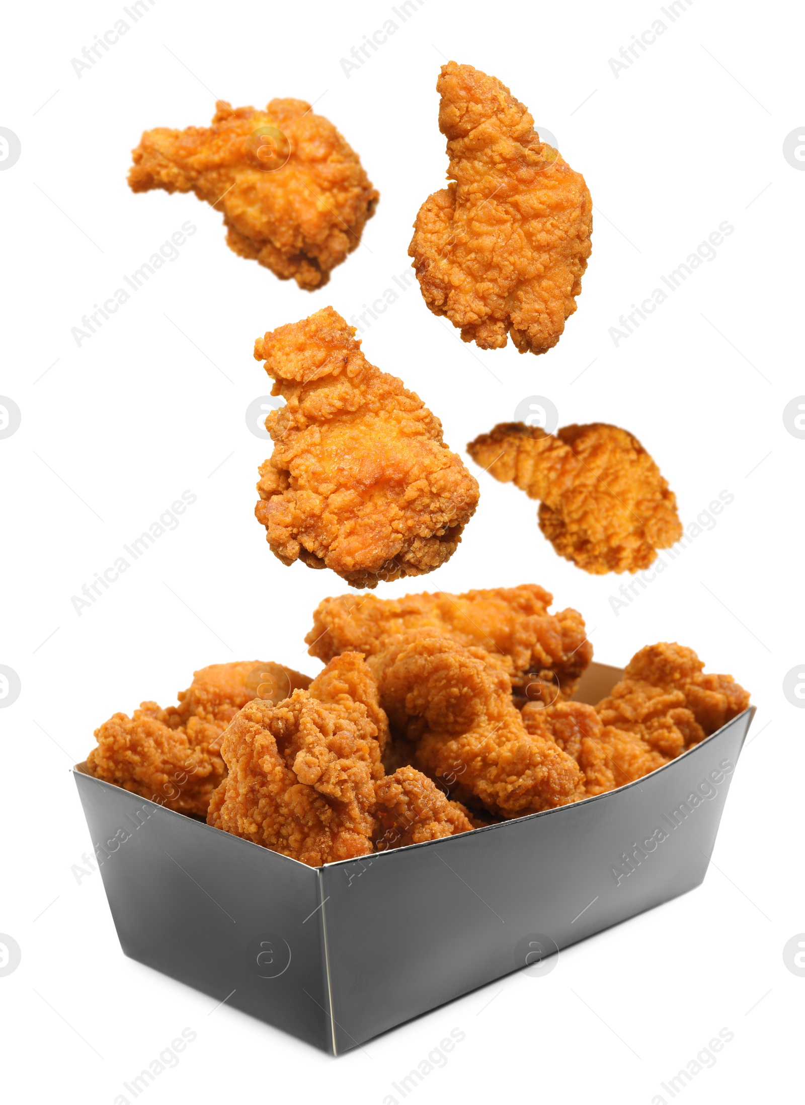 Image of Fresh fried chicken falling into container on white background