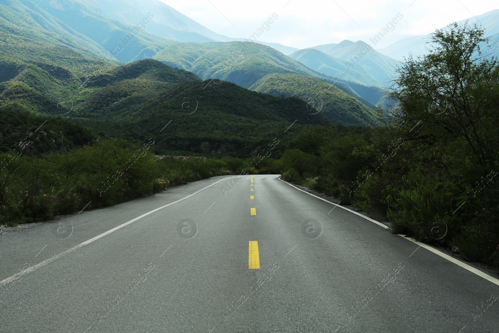 Photo of Beautiful view of empty asphalt highway near mountains outdoors. Road trip