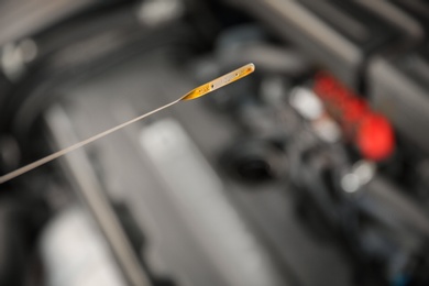 Checking car engine oil level with dipstick, closeup