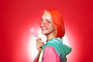 Photo of Beautiful young woman with bright dyed hair holding ice cream on color background