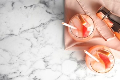 Flat lay composition with glasses of grapefruit cocktails on marble background. Space for text