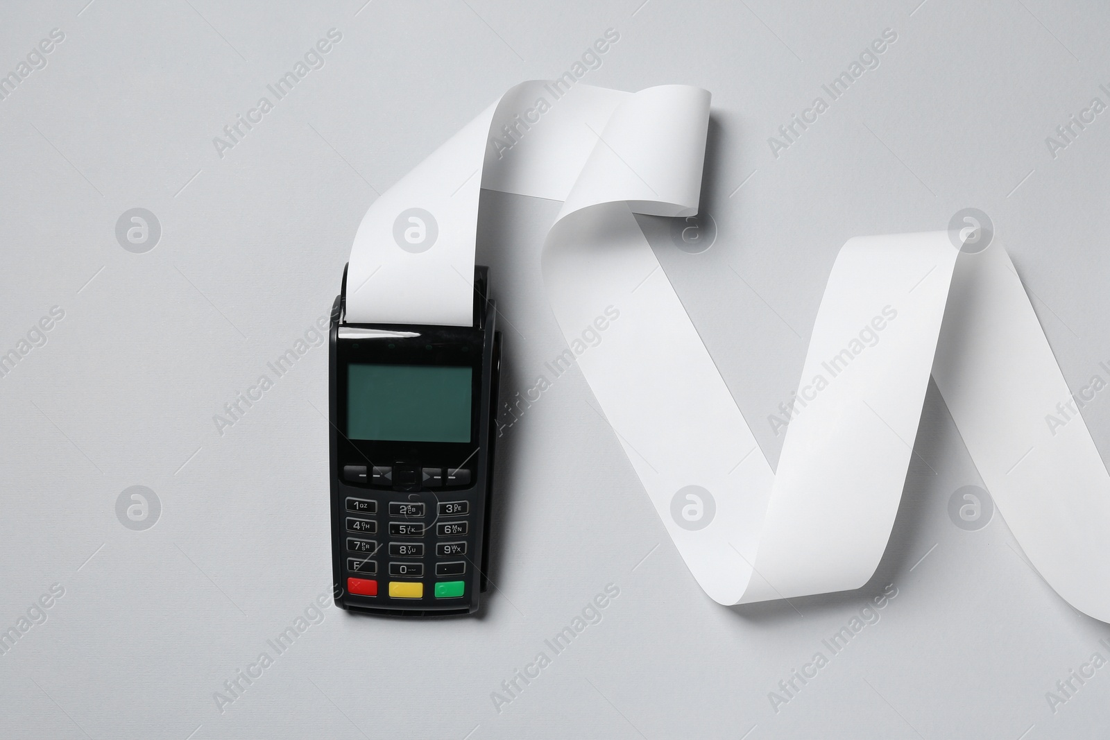 Photo of Payment terminal with thermal paper for receipt on light grey background, top view