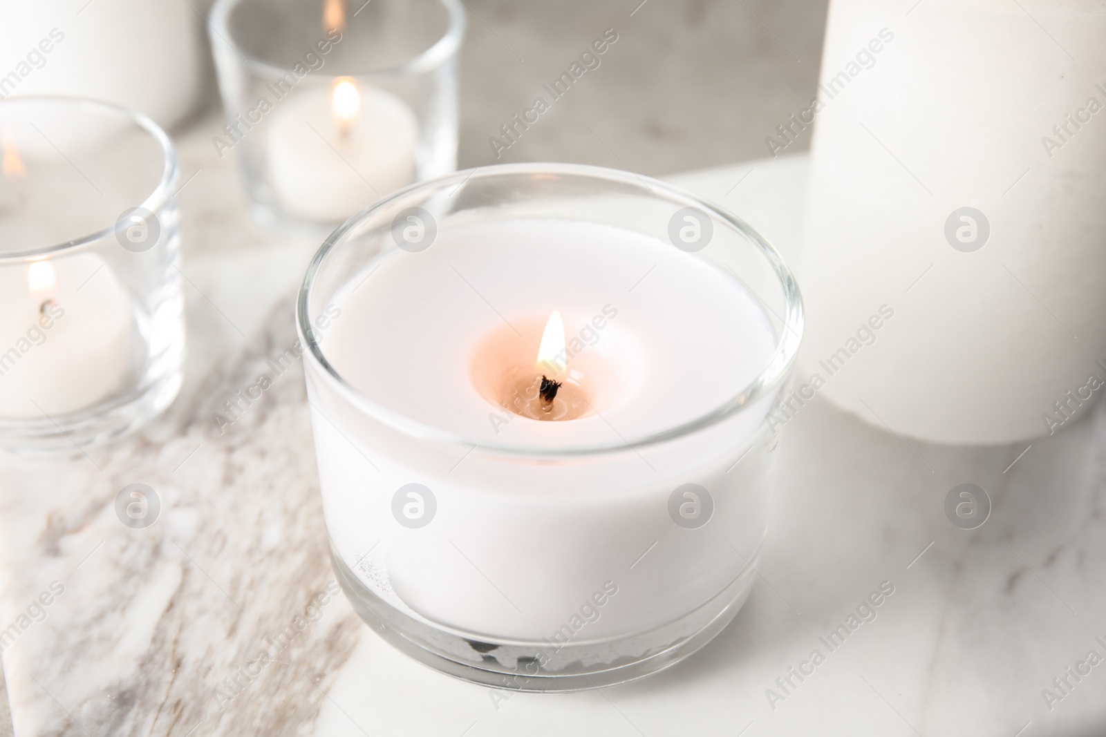 Photo of Burning aromatic candle in holder on table