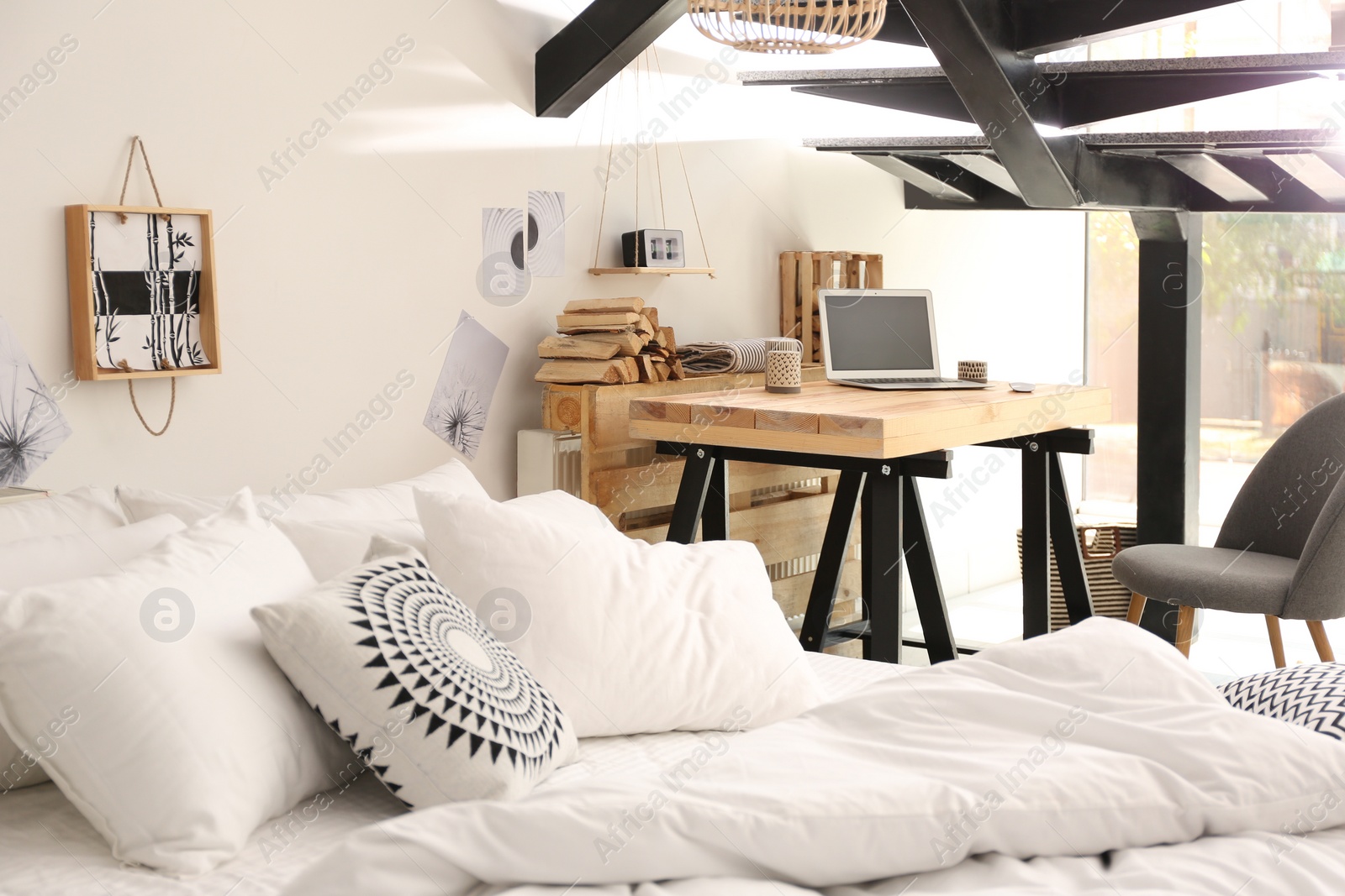 Photo of Elegant interior of bedroom with workplace under stairs