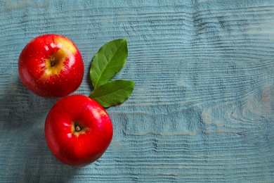 Ripe red apples on wooden background, flat lay