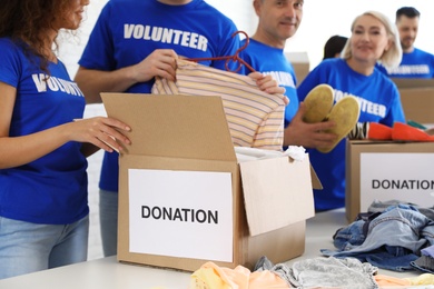 Photo of Team of volunteers collecting donations in boxes indoors