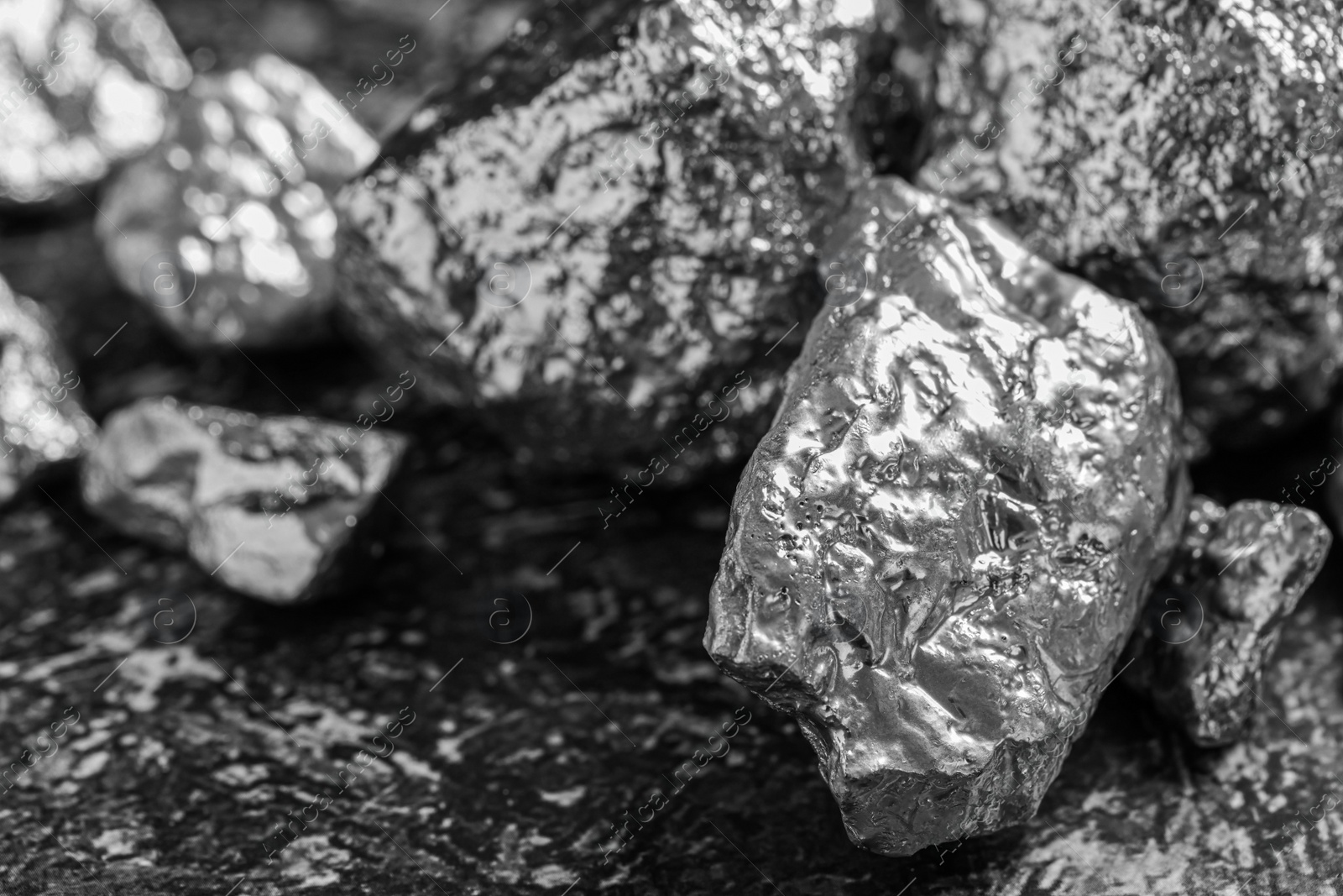 Photo of Pile of silver nuggets on grey textured table, closeup